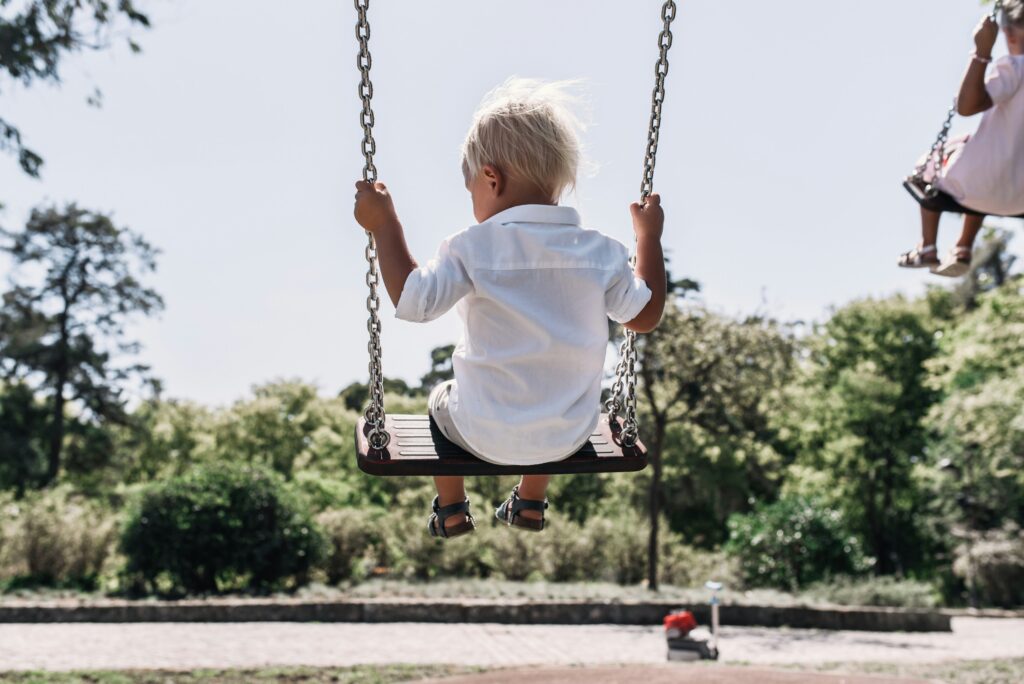 child swinging on swing set